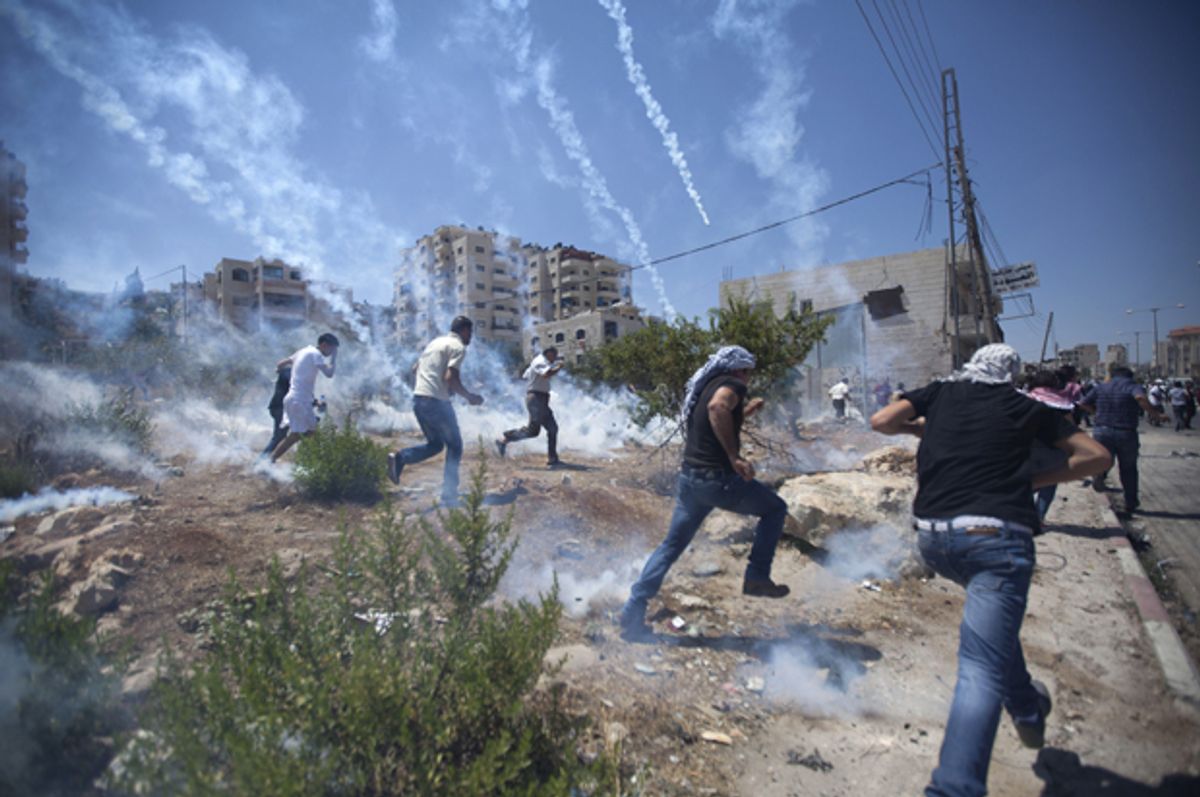 Palestinians run for cover during clashes with Israeli soldiers following a protest against the war in the Gaza Strip, outside Ofer, an Israeli military prison near the West Bank city of Ramallah, Aug. 1, 2014.       (AP/Majdi Mohammed)