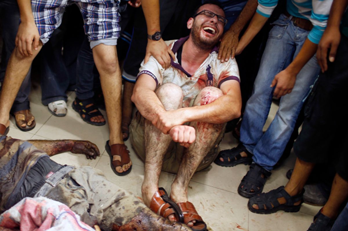 A Palestinian mourns next to the body of a man, who medics said was killed by Israeli shelling near a market in Shejaia, at a hospital in Gaza City, July 30, 2014.           (Reuters/Mohammed Salem)