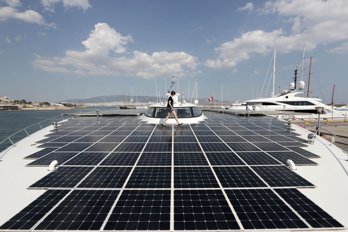 PlanetSolar press officer Julia Tames walks across the deck of the MS Turanor PlanetSolar, the world's largest solar-powered boat, moored at Zea Harbor, in Athens, on Tuesday Aug. 5, 2014. The 35-meter (115-foot) vessel is in Greece to take part in a Swiss-Greek underwater archaeology project to survey the seabed off a major prehistoric site, in hope of finding traces of what could be one of the earliest villages in Europe. (AP Photo/Thanassis Stavrakis) (AP)