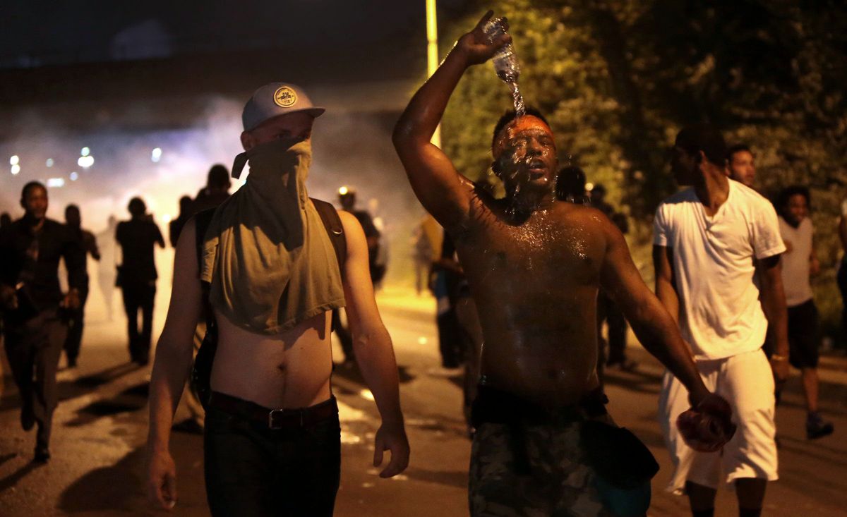 Protestors retreat from tear gas after marching toward police in Ferguson, Mo., Sunday, Aug. 17, 2014. As night fell Sunday in Ferguson, another peaceful protest quickly deteriorated after marchers pushed toward one end of a street. Police attempted to push them back by firing tear gas and shouting over a bullhorn that the protest was no longer peaceful. (AP Photo/St. Louis Post-Dispatch, Robert Cohen) (AP)