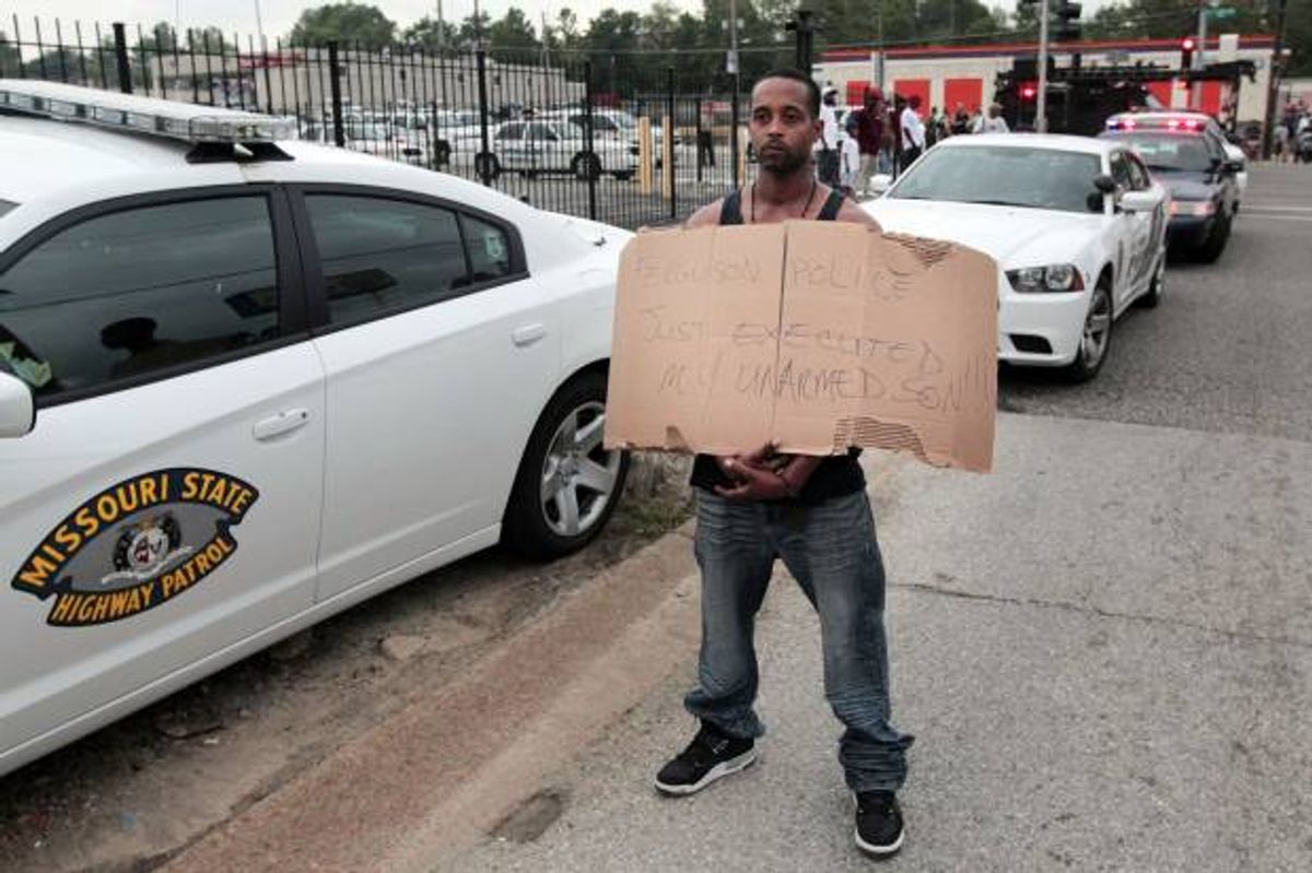 Louis Head, stepfather to 18-year-old Michael Brown who was fatally shot by police, holds a sign in Ferguson, Mo., near St. Louis on Saturday, Aug. 9, 2014        (AP Photo/St. Louis Post-Dispatch, Huy Mach)