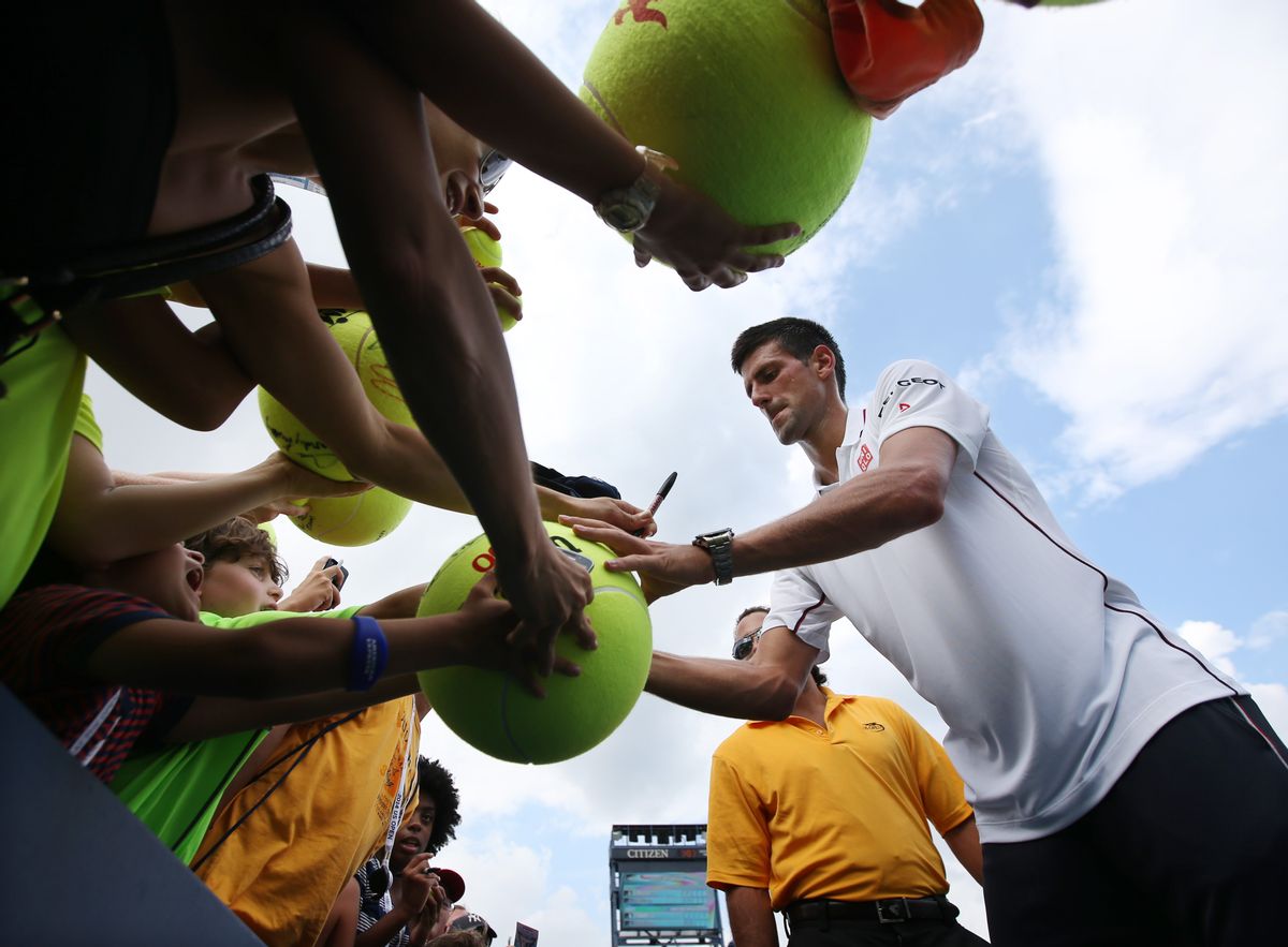 Novak Djokovic, of Serbia, signs autographs for fans after defeating Philipp Kohlschreiber, of Germany, during the fourth round of the 2014 U.S. Open tennis tournament, Monday, Sept. 1, 2014, in New York. (AP Photo/John Minchillo) (John Minchillo)
