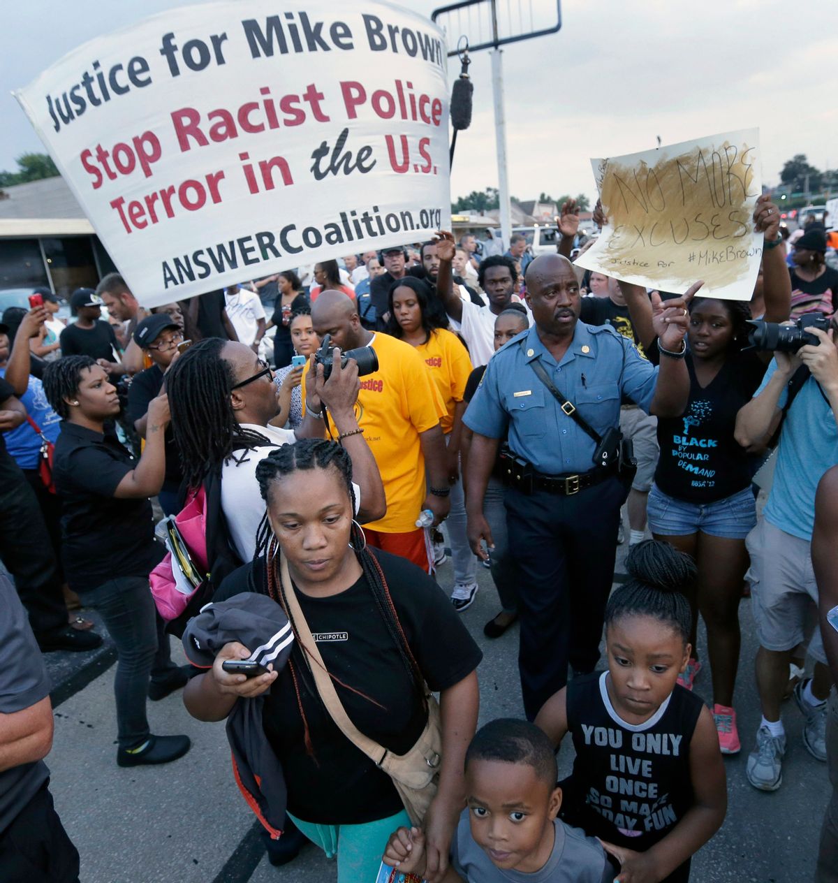 In this Aug, 16, 2014 file photo, Missouri Highway Patrol Capt. Ron Johnson walks among people protesting the police shooting death of Michael Brown a week ago in Ferguson, Mo. The Ferguson City Council, set to meet Tuesday, Sept. 9, 2014, for the first time since the fatal shooting of Brown, said it plans to establish a review board to help guide the police department and make other changes aimed at improving community relations.   (AP/Charlie Riedel)