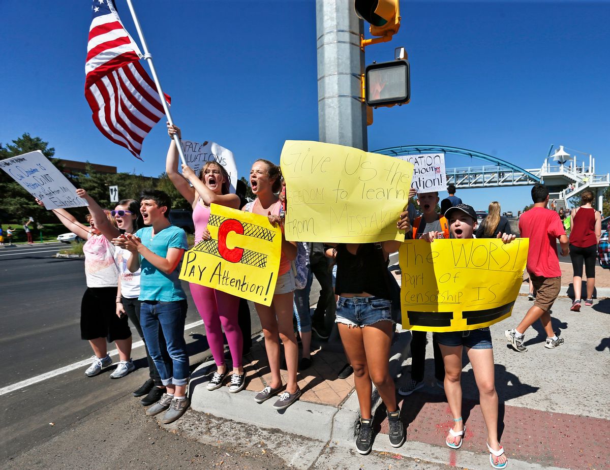 Students line a busy intersection protesting against a Jefferson County School Board proposal to emphasize patriotism and downplay civil unrest in the teaching of U.S. history, in the Denver suburb of Littleton,Thursday, Sept. 25, 2014. Several hundred students walked out of class Thursday in the fourth straight day of protests in Jefferson County.  (AP Photo/Brennan Linsley)