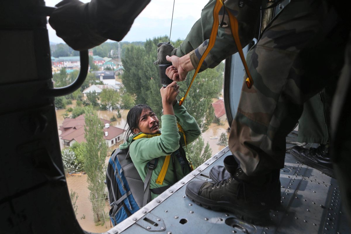 In this Tuesday, Sept. 9, 2014, an Indian tourist cries as she is airlifted into a chopper in Srinagar, India. The death toll from floods in Pakistan and India reached 400 on Tuesday and have put more than half a million people in peril and rendered thousands homeless in the two neighboring states. The tourist was stranded on the terrace of a five-storey hotel in central Srinagar. (AP Photo/Dar Yasin) (AP)