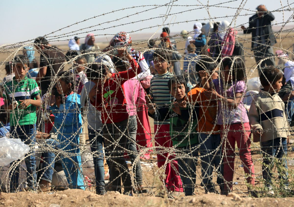 Several hundred Syrian refugees wait to cross into Turkey at the border in Suruc, Turkey, Sunday, Sept. 21, 2014. Turkey opened its border Saturday to allow in up to 60,000 people who massed on the Turkey-Syria border, fleeing the Islamic militantsâ advance on Kobani.(AP Photo/Burhan Ozbilici) (Burhan Ozbilici)
