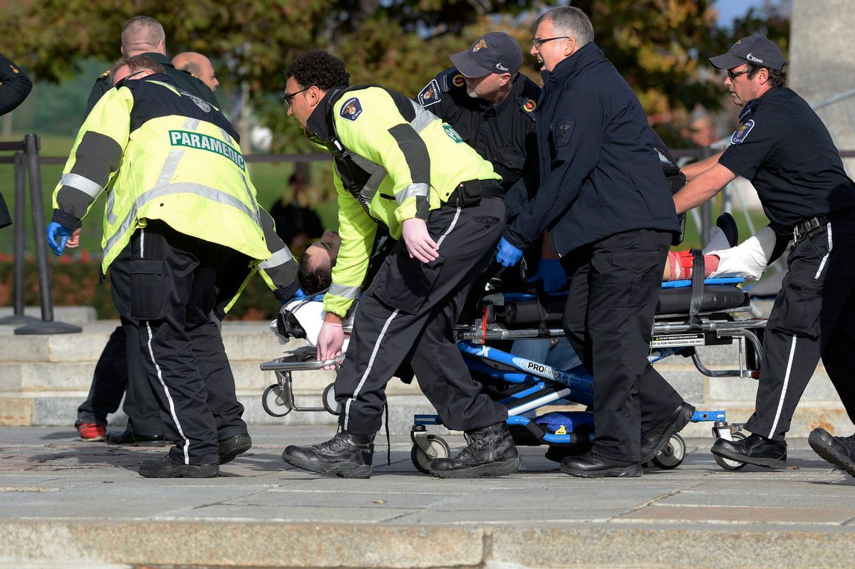 Paramedics and police pull a victim away from the Canadian War Memorial in Ottawa, Ontario, on Wednesday, Oct. 22, 2014. (AP Photo/The Canadian Press, Adrian Wyld)   (AP)