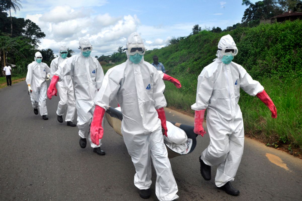 Burial team in protective gear carry a body of woman suspected to have died from Ebola virus in Monrovia, Liberia, Oct, 18, 2014.             (AP/Abbas Dulleh)