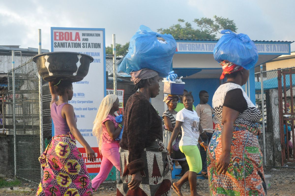 Liberia women walk past a sign warning people of the deadly Ebola virus in Monrovia, Liberia. Friday, Oct. 10, 2014. The number of people killed in the Ebola outbreak has risen above 4,000, according to the World Health Organization.  (AP Photo/ Abbas Dulleh) (AP)
