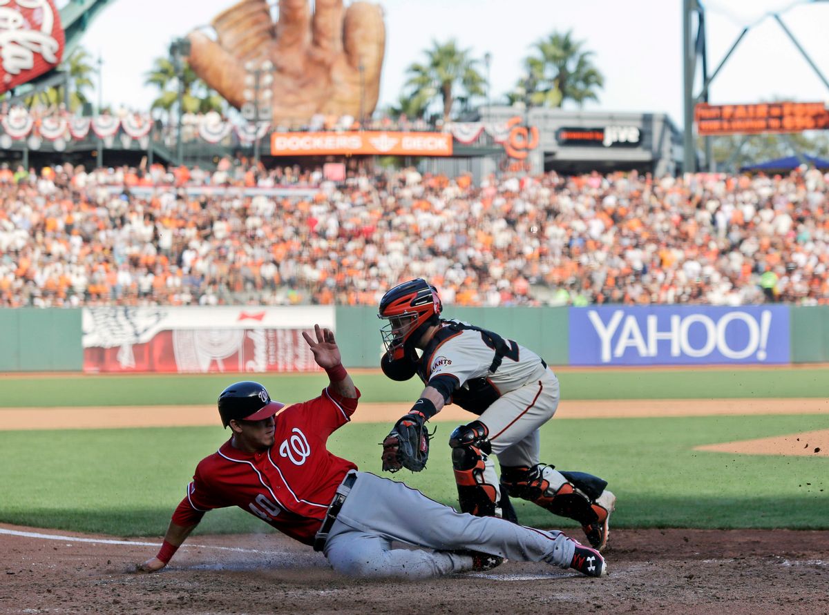 Washington Nationals Wilson Ramos (40) scores past the tag of San Francisco Giants catcher Buster Posey in the seventh inning during Game 3 of baseball's NL Division Series in San Francisco, Monday, Oct. 6, 2014.(AP Photo/Marcio Jose Sanchez) (AP)