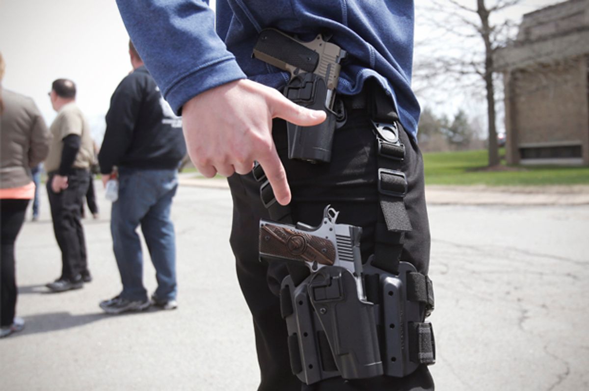 A gun rights supporter openly carries two pistols strapped to his leg during a rally in support of the Michigan Open Carry gun law in Romulus, Michigan April 27, 2014.        (Reuters/Rebecca Cook)