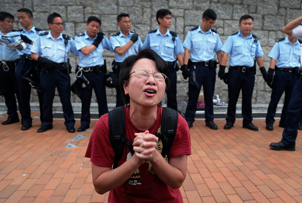 A student protester gets emotional while pleading for a peaceful resolution as some others resist during a change of shift for local police but backed down after being reassured they could reoccupy the pavement outside the government compoundâs gate, Thursday, Oct. 2, 2014 in Hong Kong. Hong Kong police warned of serious consequences if pro-democracy protesters try to occupy government buildings, as they have threatened to do if the territory's leader doesn't resign by Thursday. (AP Photo/Wong Maye-E) (Wong Maye-e)