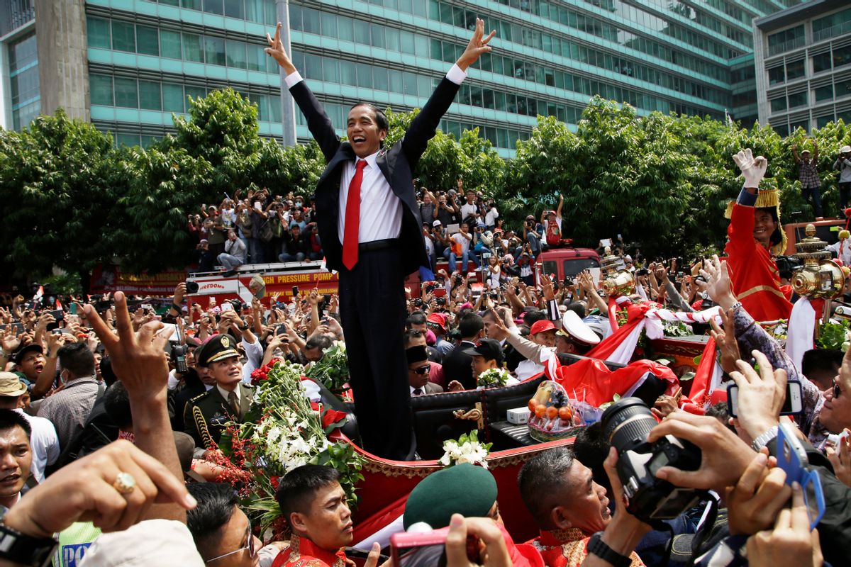 In this Monday, Oct. 20, 2014 photo, Indonesian President Joko Widodo gestures to the crowd during a street parade following his inauguration in Jakarta, Indonesia. (AP Photo/Achmad Ibraham) (AP)