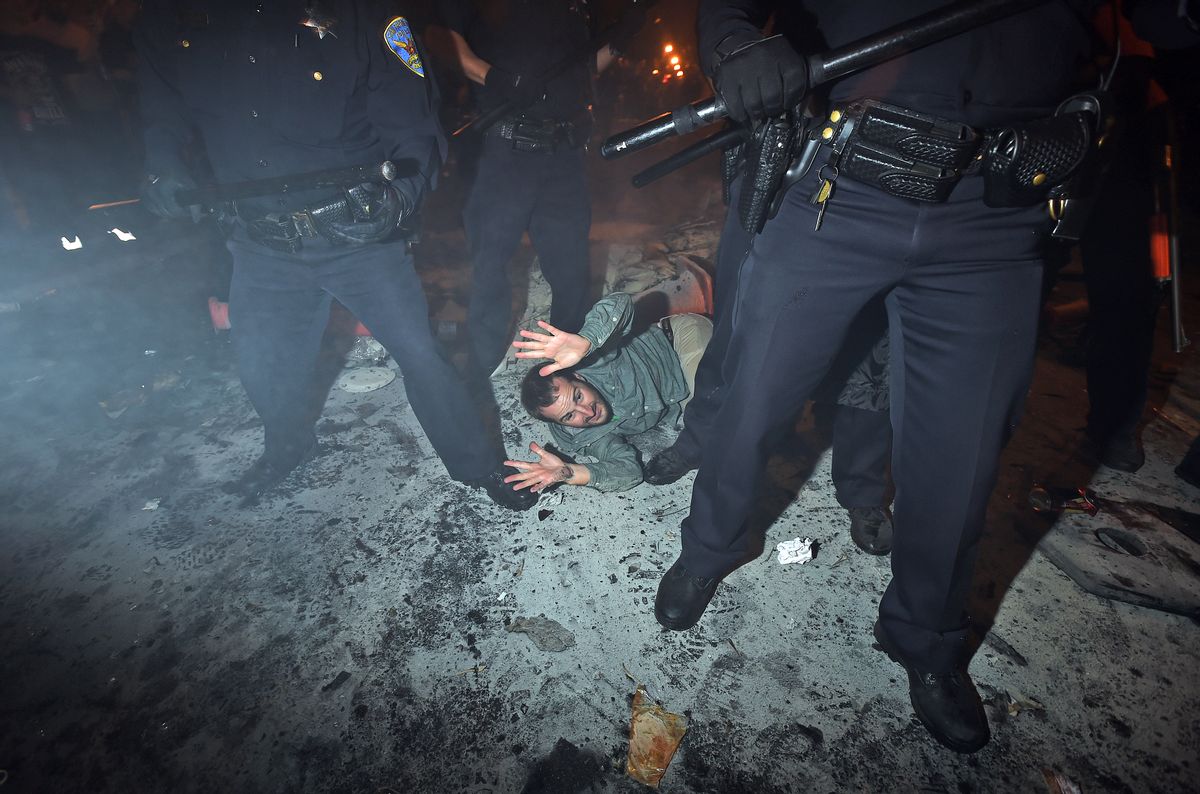 San Francisco police officers subdue a man who was seen driving a meter maid vehicle through the Mission district after the San Francisco Giants won the World Series baseball game against the Kansas City Royals on Wednesday, Oct. 29, 2014, in San Francisco.  There were several reports of fires being set and violence breaking out after the Giants win. (AP Photo/Noah Berger) (AP)