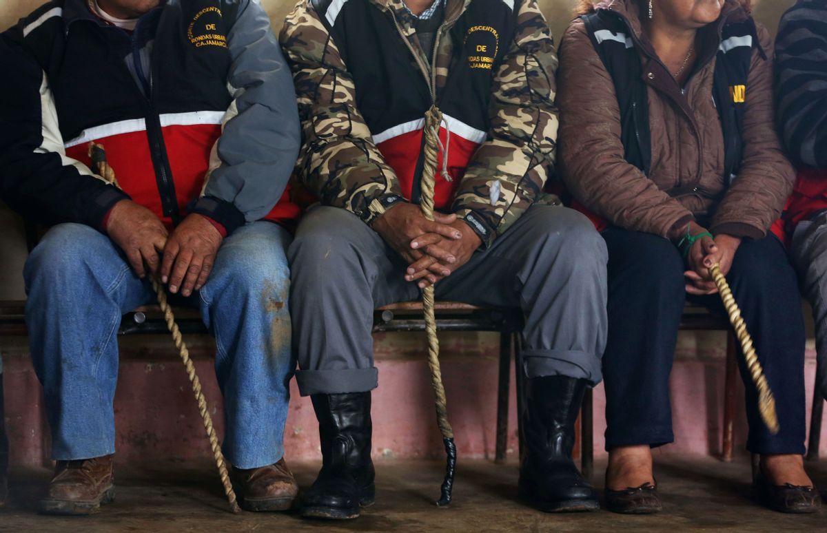 In this May 9, 2014 photo, men and women, all wearing citizen patrol vests and wielding whips, take part in a hearing of an accused community member, in the Cajamarca municipality, Santa Rosa de Chumbil, Peru. For all but the most serious crimes, this is how justice is routinely administered in this highlands provincial capital of 200,000 people: self-appointed bands of vigilantes known as "rondos urbanas," or urban patrols, take on the roles of police, prosecutors and judges. (AP Photo/Martin Mejia) (AP)