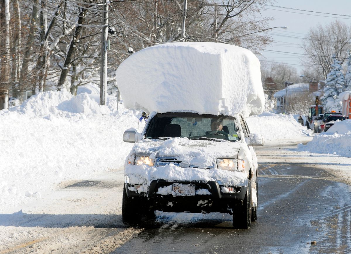 A vehicle, with a large chunk of snow on its top, drives along Route 20 after digging out after a massive snow fall in Lancaster, N.Y. Wednesday, Nov. 19, 2014. Another two to three feet of snow is expected in the area. (AP Photo/Gary Wiepert) (AP)