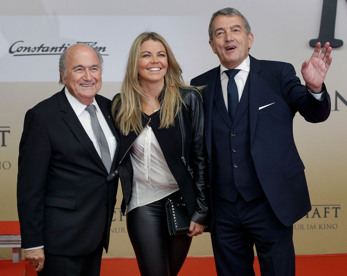 Wolfgang Niersbach, President of the German Soccer Association (DFB), right, FIFA President Sepp Blatter, left, and Niersbach's partner Marion Popp, center, pose for the media as they arrive for the premiere of the movie 'Die Mannschaft' (The Team) in Berlin, Germany, Monday, Nov. 10, 2014. (AP Photo/Michael Sohn) (AP)