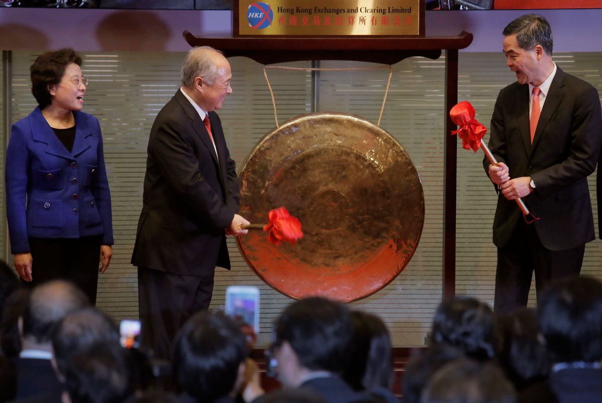 Hong Kong Exchanges and Clearing Ltd. Chairman Chow Chung-kong, second from left,  and Hong Kong Chief Executive Leung Chun-ying, third from left, smile before hitting a gong during the launch ceremony of the Shanghai-Hong Kong Stock Connect in Hong Kong Monday, Nov. 17, 2013. Stock exchanges in Hong Kong and Shanghai kicked off trading Monday on a cross-border stock link that will allow foreign investors wider access to mainland China's tightly restricted equity market. (AP Photo/Vincent Yu) (Vincent Yu)