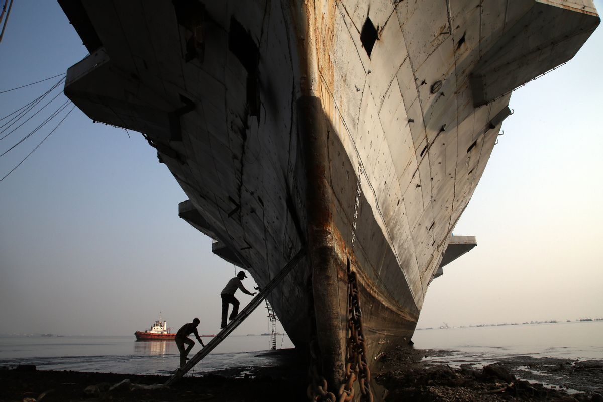 Workers climb to enter India's first aircraft carrier INS Vikrant to dismantle it at a ship-breaking yard in Mumbai, India, Saturday, Nov. 22, 2014. The iconic naval vessel, that was purchased from Britain in 1957, played a key role during the India-Pakistan war of 1971 and was decommissioned in 1997. (AP Photo/Rajanish Kakade) (AP)