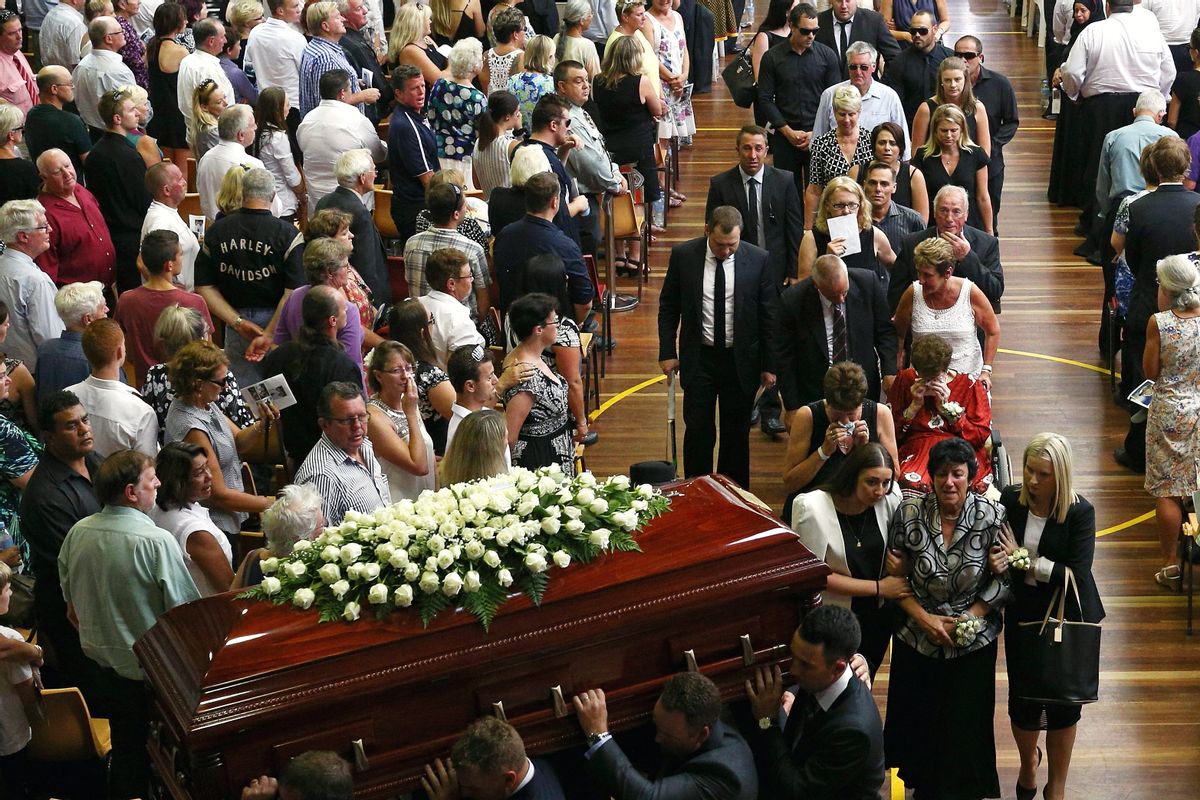 The coffin of Phillip Hughes is carried down the aisle as his mother, Virginia Hughes, second right at bottom, is comforted during his funeral in Macksville, Australia, Wednesday, Dec. 3, 2014. Hughes died last Thursday, two days after he was hit in the head during a domestic cricket match. (AP Photo/Cameron Spencer, Pool) (Cameron Spencer)