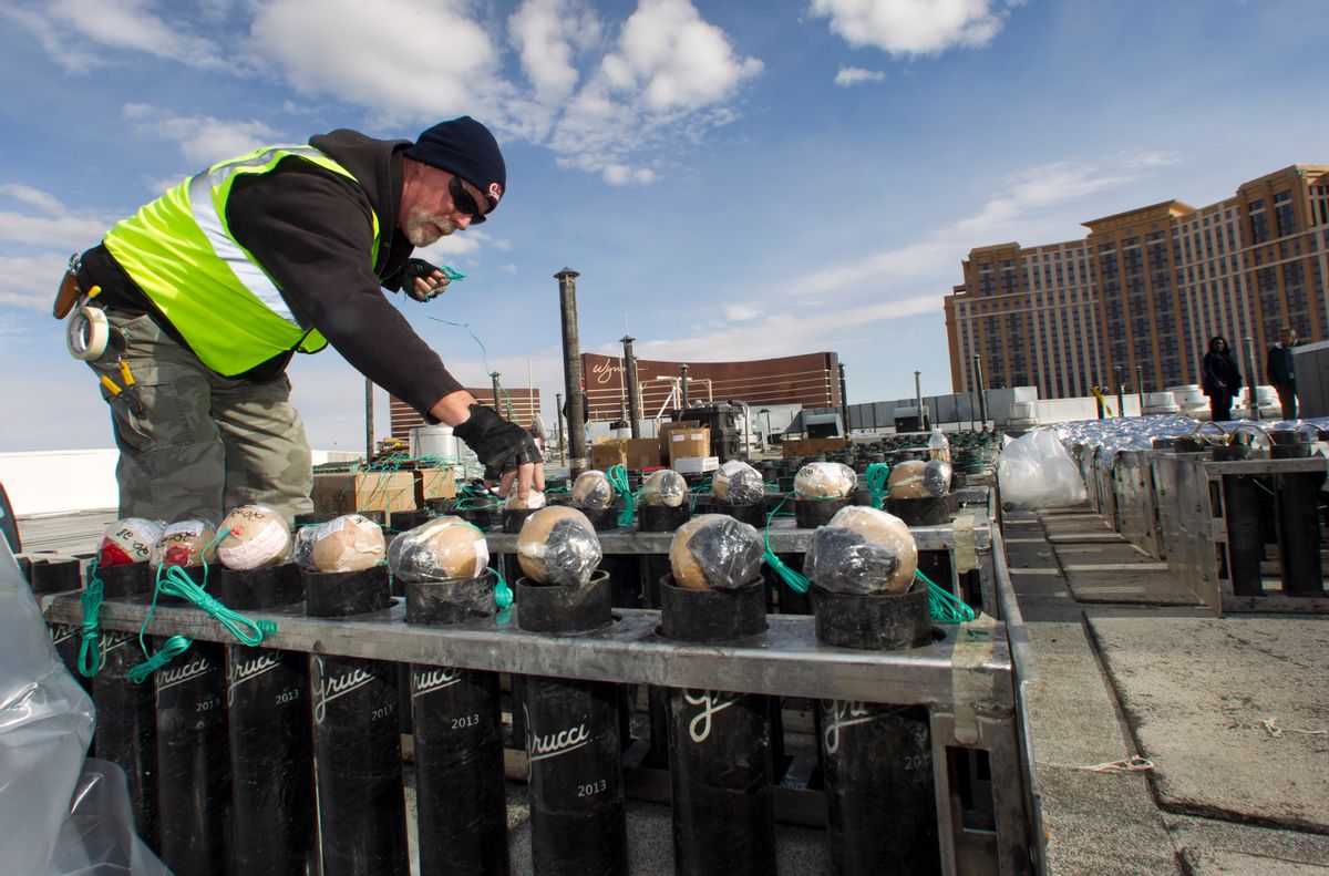 Pyrotechnician Henry Herman loads aerial shells during New Years Eve fireworks preparation on the roof of the Treasure Island hotel-casino in Las Vegas, Tuesday, Dec. 30, 2014. The Fireworks by Grucci show will explode from the rooftops of seven casinos. (AP Photo/Las Vegas Sun, Steve Marcus) (AP)