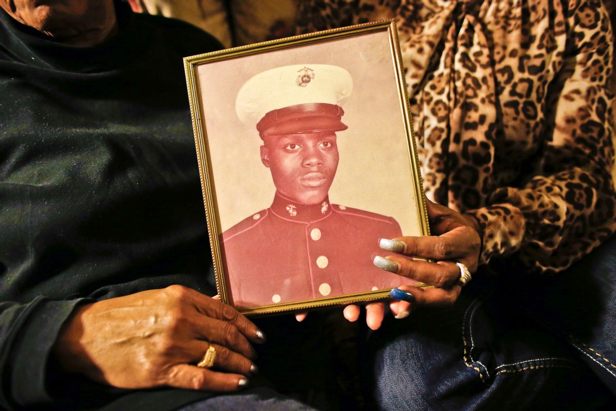FILE - In this March 12, 2014 file photo, a picture of Jerome Murdough, a former homeless Marine who died in a mental observation unit on Rikers Island jail on Feb. 15, is held by his mother Alma Murdough left, and sister Cheryl Warner at Alma Murdough's home in the Queens borough of New York. New York Mayor Bill de Blasio plans to announce his $130 million, four-year plan to overhaul how the nations most populous city deals with mentally ill and drug-addicted suspects, diverting many to treatment instead of jail.  (AP Photo/Jason DeCrow, File) (AP)