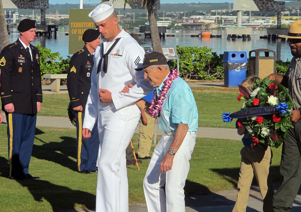 A Navy sailor escorts Navy veteran and Pearl Harbor survivor John Chapman during a ceremony to mark the 73rd anniversary of the Japanese attack on Pearl Harbor, Sunday, Dec. 7, 2014, at Pearl Harbor, Hawaii. The attack launched the U.S. into World War II. (AP Photo/Jennifer Sinco Kelleher) (AP)