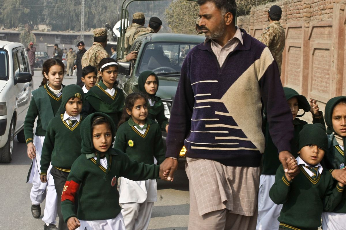 A plainclothes security officer escorts students evacuated from a school as Taliban fighters attack another school nearby, killing148 people, mostly children, in Peshawar, Pakistan, Tuesday, Dec. 16, 2014. U.S. Secretary of State John Kerry condemned the attacks: "Mothers and fathers send their kids to school to learn and to be safe and to dream and to find opportunity. And particularly at this military school in Pakistan, they sent their kids there with the hope and dreams of serving their country. Instead, today they are gone, wiped away by Taliban assassins who serve a dark and almost medieval vision, and the opposite of everything that those mothers and fathers wanted for their children." (AP Photo/Mohammad Sajjad) (AP)