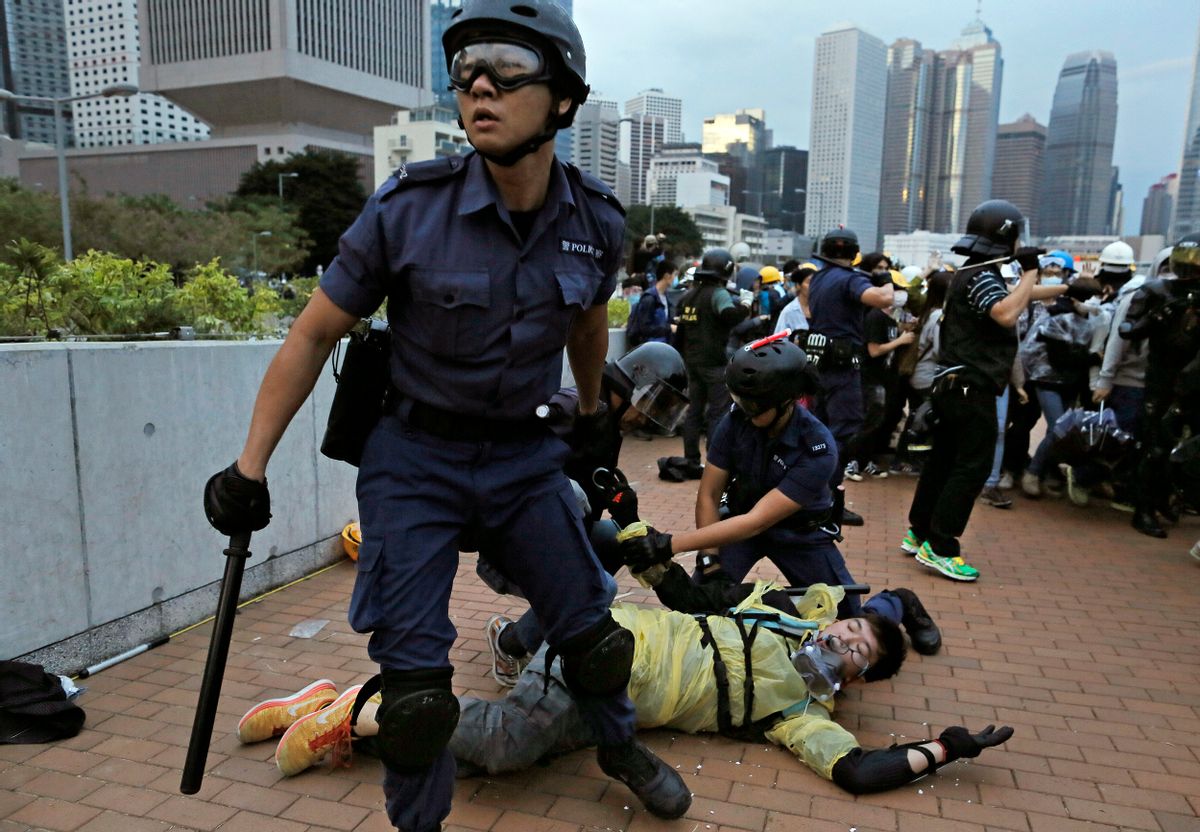 A protester is arrested by police officers outside government headquarters in Hong Kong Monday, Dec. 1, 2014. Pro-democracy protesters clashed with police as they tried to surround Hong Kong government headquarters late Sunday, stepping up their movement for genuine democratic reforms after camping out on the city's streets for more than two months. (AP Photo/Vincent Yu) (Vincent Yu)