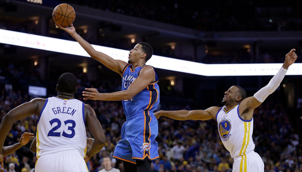 Oklahoma City Thunder guard Andre Roberson lays up a shot between Golden State Warriors' Draymond Green (23) and Andre Iguodala during the second half of an NBA basketball game Thursday, Dec. 18, 2014, in Oakland, Calif. The Warriors won 114-109. (AP Photo/Ben Margot) (AP)
