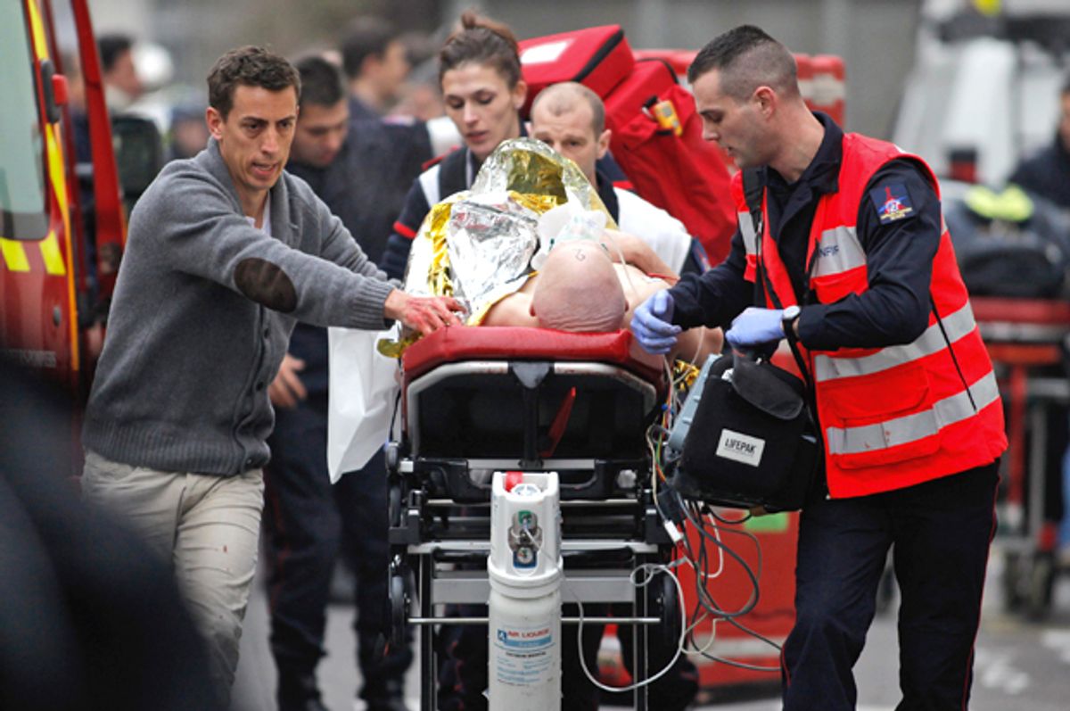 An injured person is transported to an ambulance after a shooting at the French satirical newspaper Charlie Hebdo's office, in Paris, Jan. 7, 2015.                (AP/Thibault Camus)