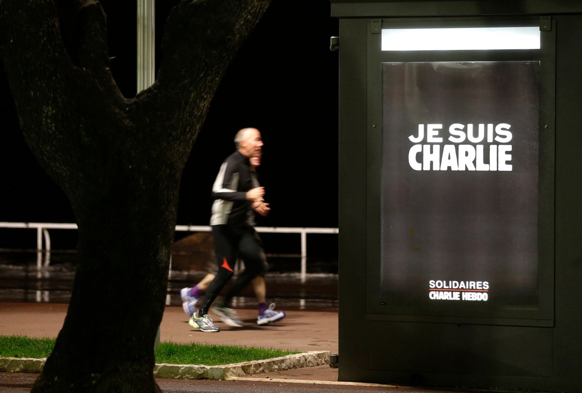 Mens runs next to a kiosk with a poster reading "I'm Charlie" on the "Promenade des Anglais"  in Nice southeastern France, Wednesday, Jan. 14, 2015. Twelve people died when two masked gunmen assaulted the Charlie Hebdo newspaper's offices on Jan. 7, including much of the editorial staff and two police. (AP Photo/ Lionel Cironneau)  (Lionel Cironneau)