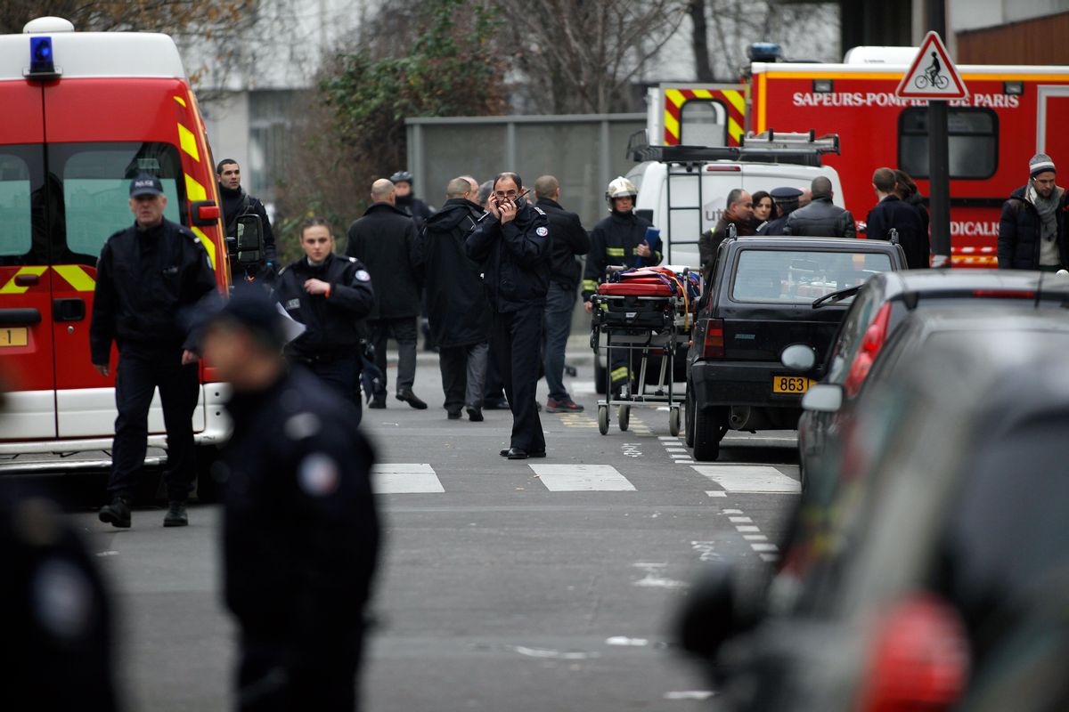 Police officers and firemen gather  outside the French satirical newspaper Charlie Hebdo's office, in Paris, Wednesday, Jan. 7, 2015. Masked gunmen stormed the offices of a French satirical newspaper Wednesday, killing at least 11 people before escaping, police and a witness said. The weekly has previously drawn condemnation from Muslims.  (AP Photo/Thibault Camus) (AP)