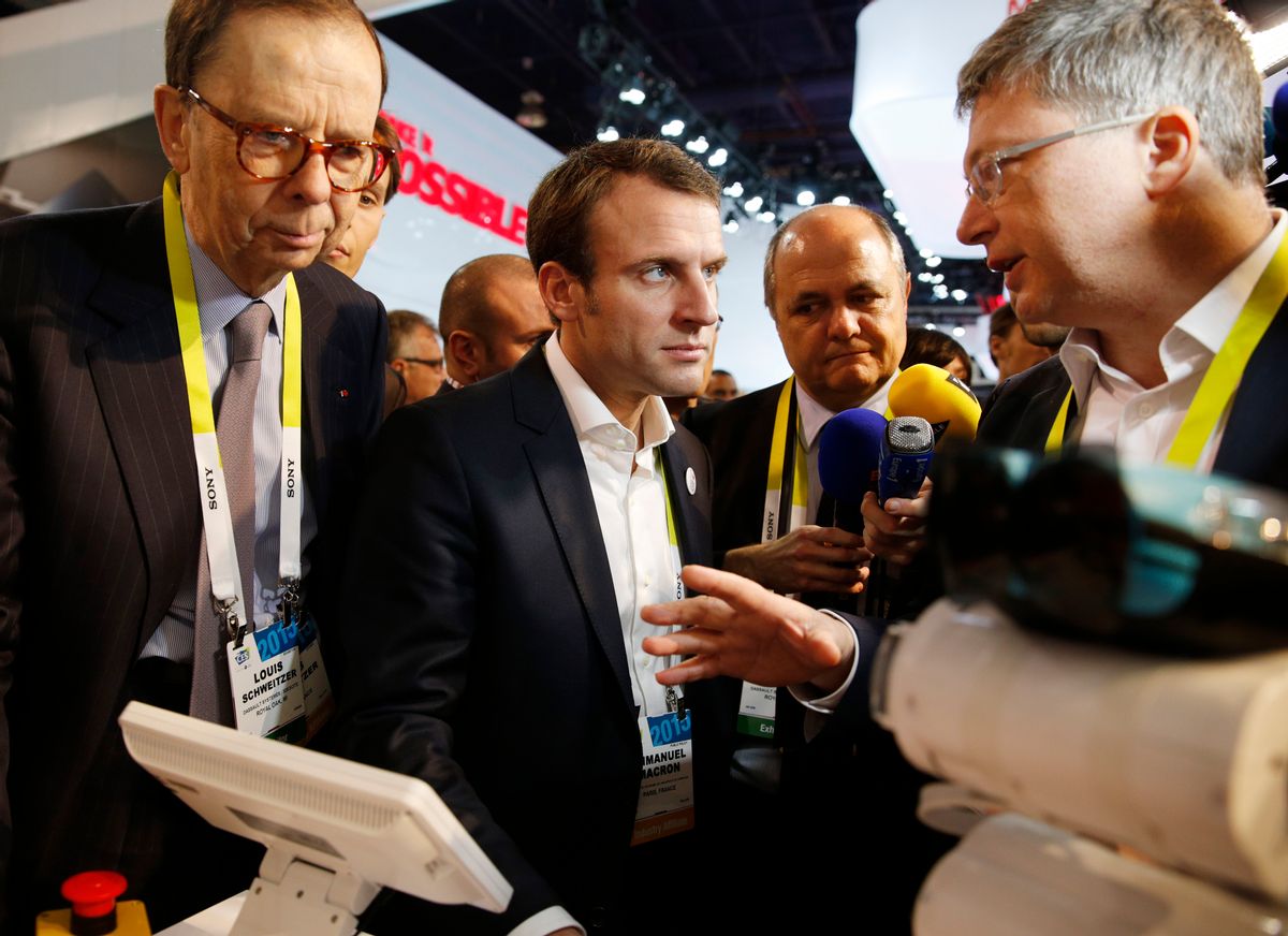 French finance minister Emmanuel Macron, center, tours the Parrot booth with Parrot CEO and founder Henri Seydoux, right, and Louis Schweitzer, left, Tuesday, Jan. 6, 2015, at the International CES in Las Vegas. (AP Photo/John Locher) (AP)