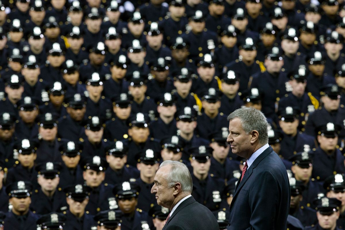 FILE - In this Monday, Dec. 29, 2014 file photo New York City Mayor Bill de Blasio, right, and NYPD police commissioner Bill Bratton, center, stand on stage during a New York Police Academy graduation ceremony at Madison Square Garden in New York.  (AP/John Minchillo)