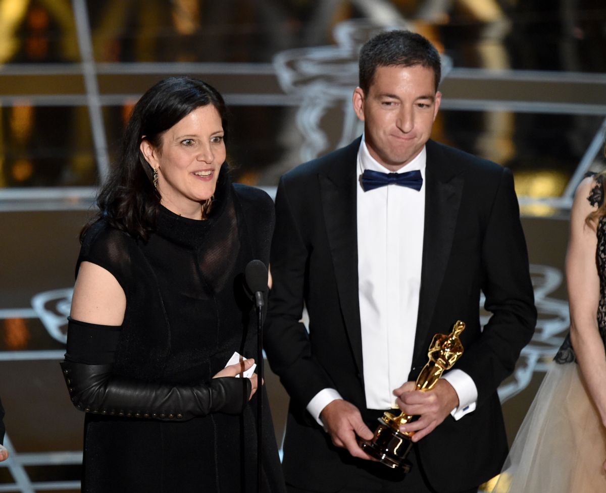 Laura Poitras, left, and Glenn Greenwald accept the award for best documentary feature for Citizenfour at the Oscars on Sunday, Feb. 22, 2015, at the Dolby Theatre in Los Angeles. (Photo by John Shearer/Invision/AP)   (John Shearer/invision/ap)
