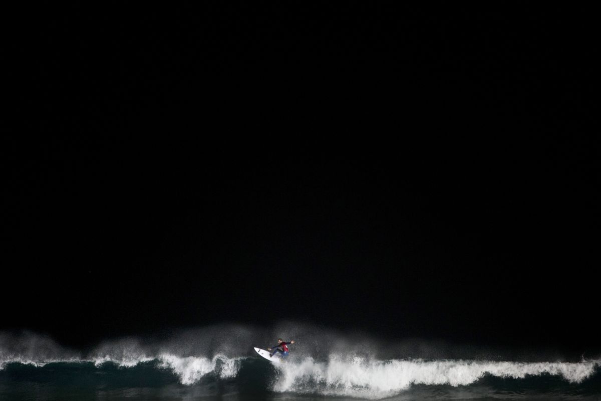 AP10ThingsToSee - A surfer catches a wave during a night surfing competition in the Mediterranean sea in Ashdod, southern Israel on Wednesday, Feb. 4, 2015. About 40 surfers participated in the competition which started Wednesday after sundown. (AP Photo/Oded Balilty) (AP)