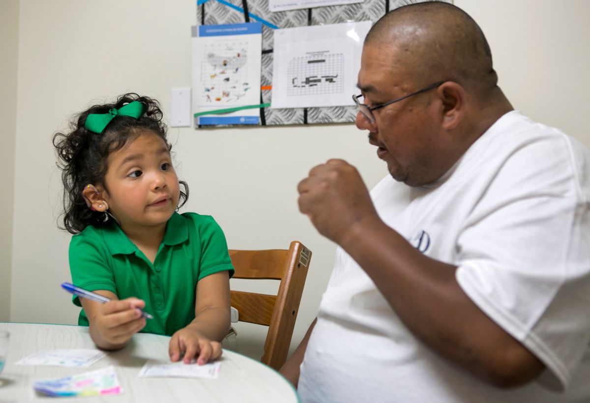 In this photo taken Feb. 11, 2015, Angelica Lopez, 3, writes her name with the help of her father, Santos Lopez, during a therapy session at the University of Southern California in Los Angeles. Angelica was born deaf and received an auditory brainstem implant to allow her to hear some sounds as part of a research study into the devices' use in young children. (AP Photo/Damian Dovarganes) (AP)