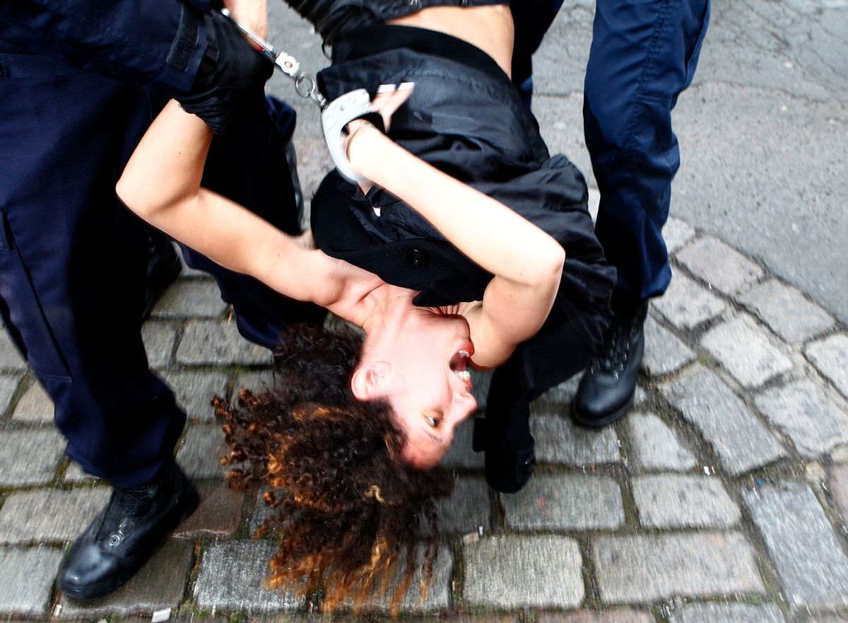 A Femen activist, is led away by police  as she  protests in front of Lille courthouse, northern France, Tuesday, Feb. 10, 2015. Dominique Strauss-Kahn goes on trial for sex charges in France. The former head of the International Monetary Fund, whose career went down in flames amid accusations of sexually assaulting a hotel maid in New York, is facing similarly shocking charges in France: aggravated pimping and involvement in a prostitution ring operating out of luxury hotels.(AP Photo/Michel Spingler) (Michel Spingler)