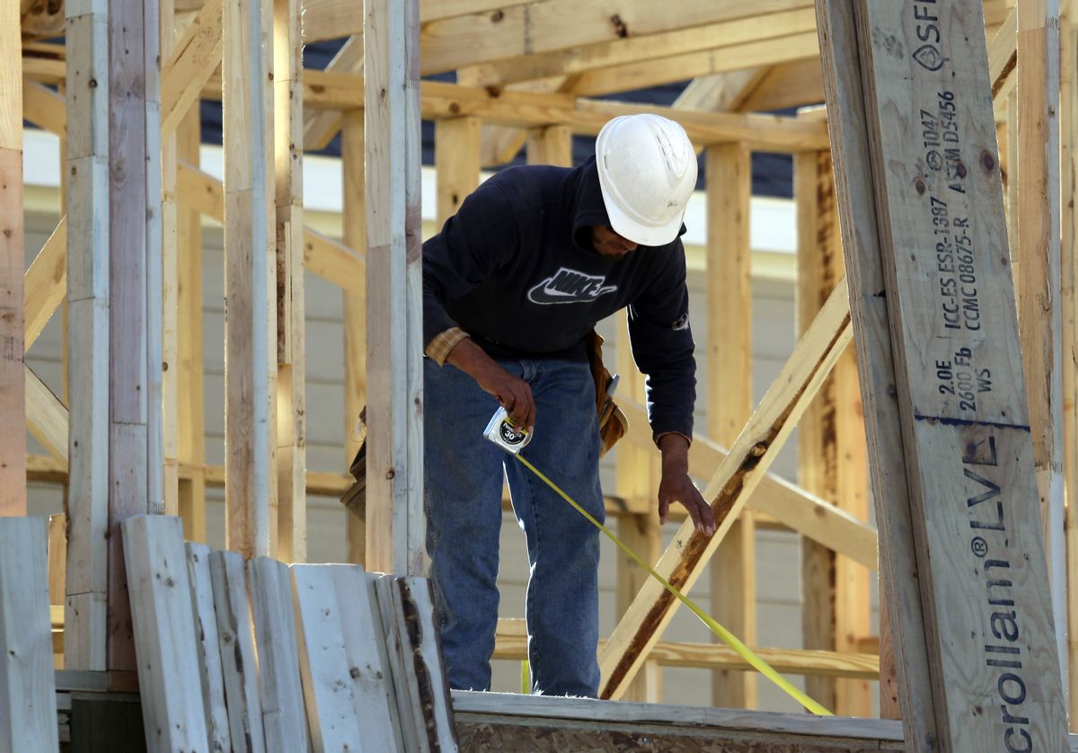 In this Dec. 15, 2014 photo, a worker measures before cutting while working on the framing of a house under construction in Coppell, Texas. The Commerce Department reports on U.S. home construction in January on Wednesday, Feb. 18, 2015. (AP Photo/LM Otero) (AP)