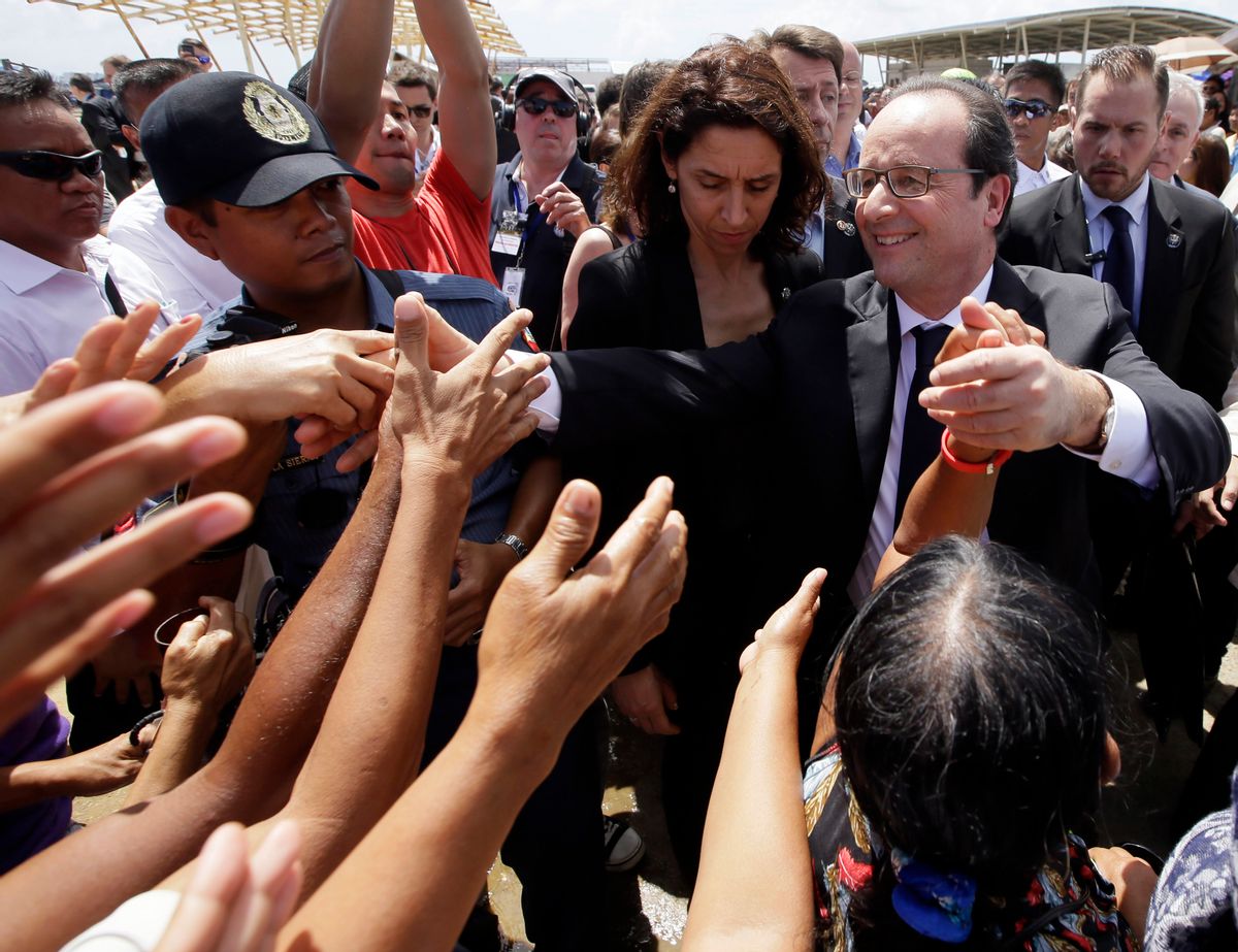 President Francois Hollande of France is greeted by the crowd during his visit to the  typhoon-ravaged Guiuan township, Eastern Samar province in central Philippines Friday, Feb. 27, 2015. Hollande's two-day state visit focuses on climate change.(AP Photo/Bullit Marquez) (Bullit Marquez)