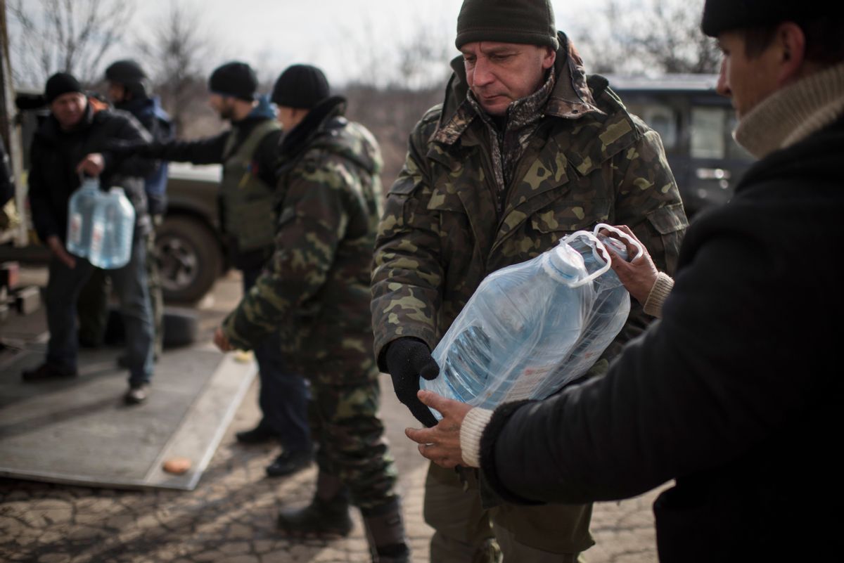Ukrainian soldiers unload supplies near Debaltseve, eastern Ukraine, Sunday, Feb. 8, 2015. The government-held town of Debaltseve, a key railway junction, has been the epicenter of recent battles between Russian-backed separatists and Ukrainian government troops. For two weeks, the town has been pounded by intense shelling that knocked out power, heat and running water in the dead of winter. (AP Photo/Evgeniy Maloletka) (AP)