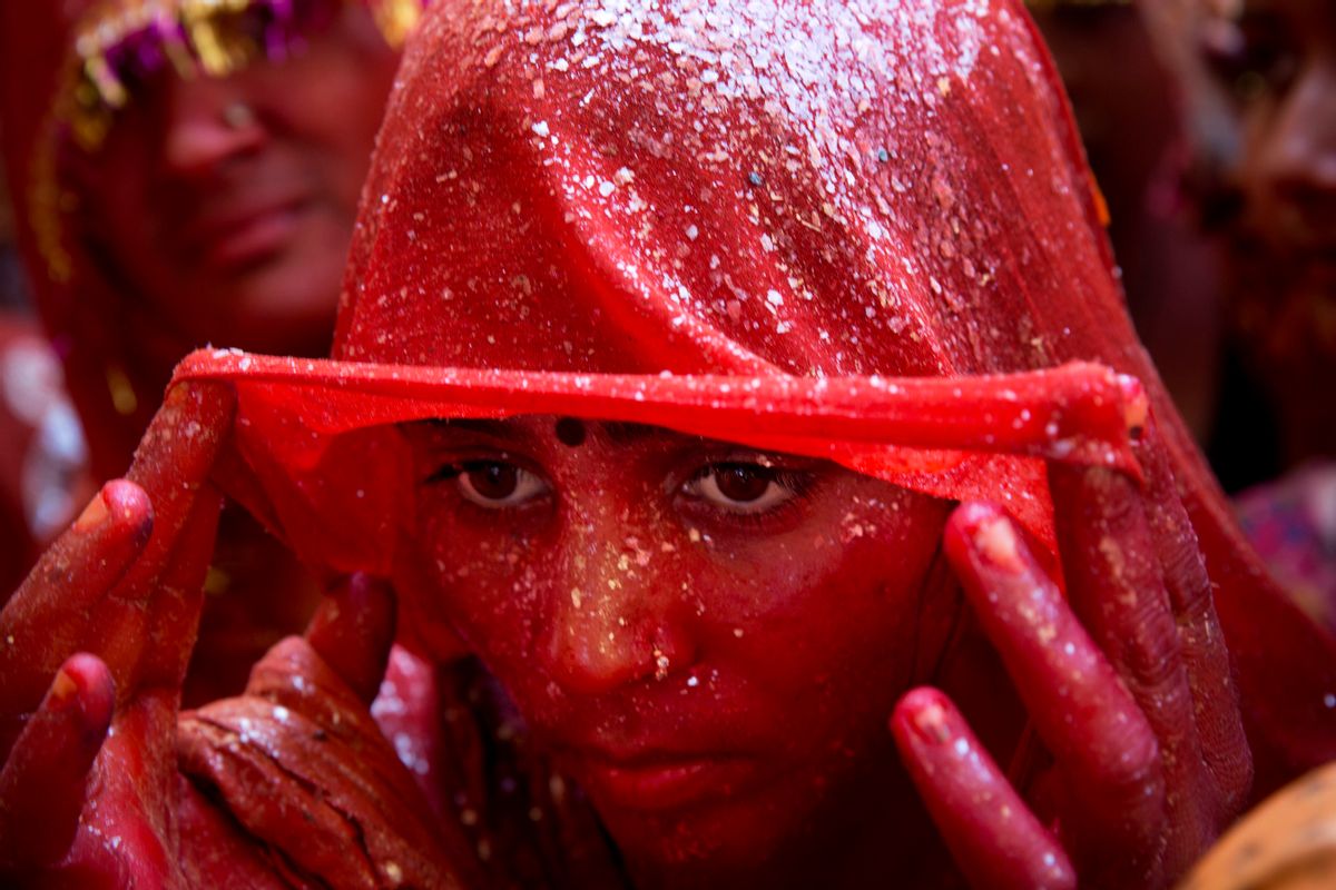 AP10ThingsToSee - A Hindu woman devotee lifts her veil as she stands drenched in colored water during "Huranga," celebrated as part of Holi, the Hindu festival of colors, at the Baldev Temple in Dauji, 180 kilometers (113 miles) south of New Delhi, India, Saturday, March 7, 2015.   (AP Photo/Bernat Armangue) (AP)