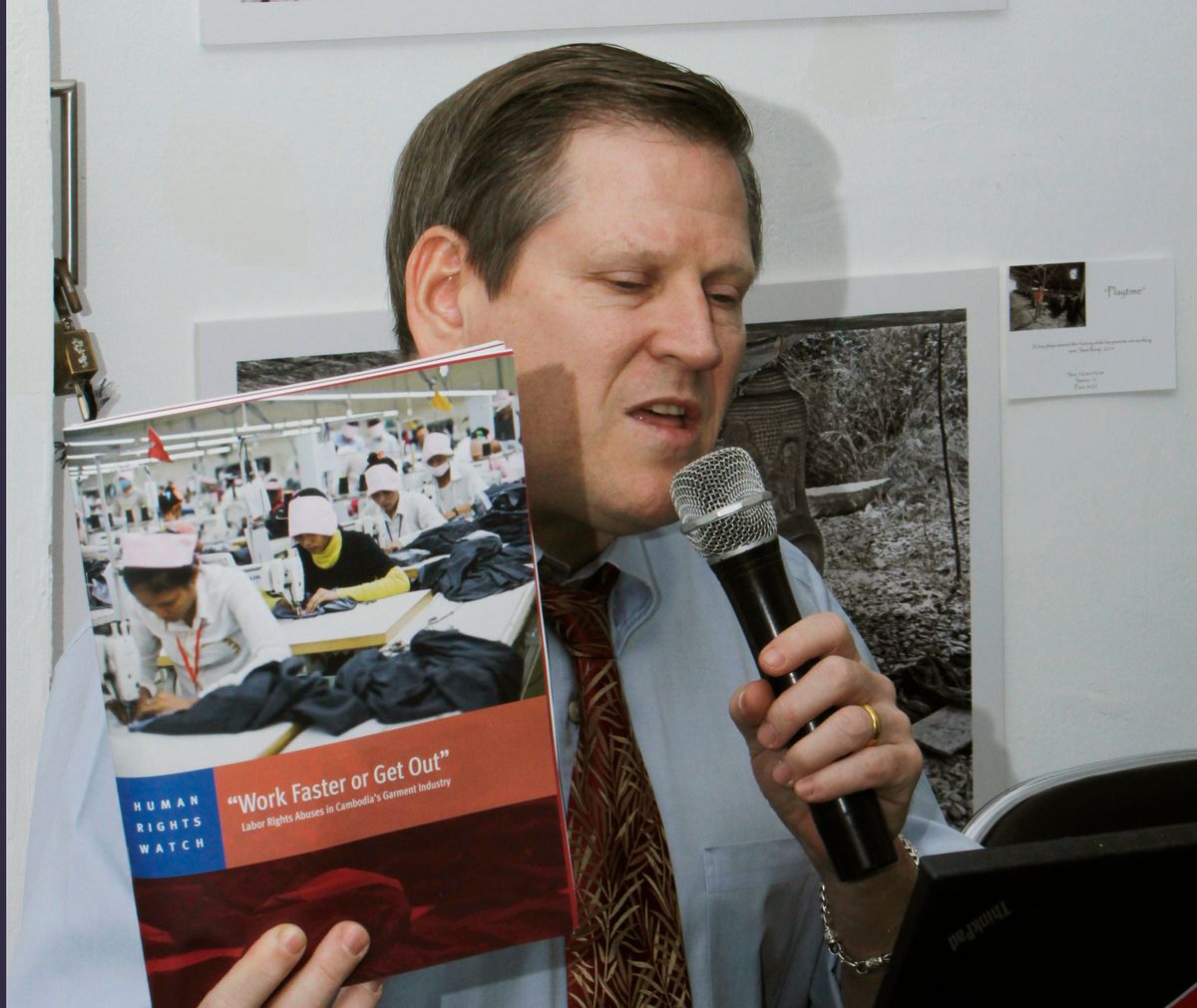 Phil Robertson, deputy director of Human Rights Watch's Asia division, speaks while showing its report during a press conference in Phnom Penh, Cambodia Thursday, March 12, 2015. Leading clothing retailers such as Gap and H&M need to help alleviate labor abuses at factories in Cambodia that manufacture their products, the New York-based human rights organization said. (AP Photo/Heng Sinith)  (Heng Sinith)