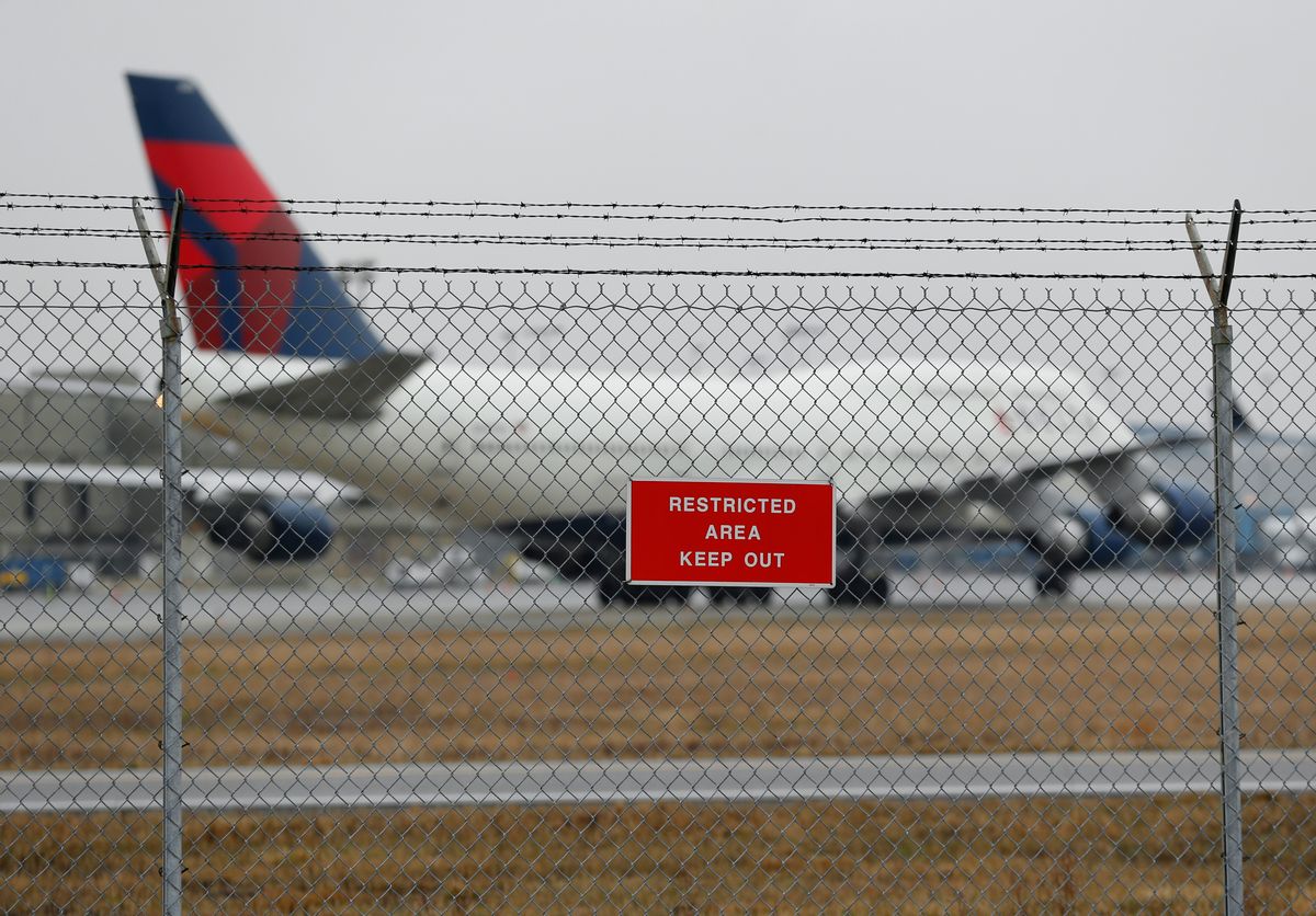 A sign is shown posted on a perimeter fence near Delta 747 aircraft taxiing at the Detroit Metropolitan Airport in Romulus, Mich., Thursday, April 9, 2015. The security fences and perimeter gates at Detroit Metropolitan Airport have been breached four times in the past two years, an Associated Press investigation shows. Nationally, at least 272 such breaches occurred at 31 major U.S. airports since the start of 2004. (AP Photo/Paul Sancya) (AP)