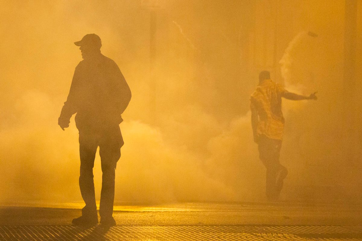 Protestors walk through smoke Tuesday, April 28, 2015, in Baltimore. (AP Photo/Matt Rourke)   (AP)
