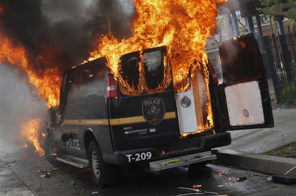 A Baltimore Metropolitan Police transport vehicle burns during clashes in Baltimore, Maryland April 27, 2015.             (Reuters/Shannon Stapleton)