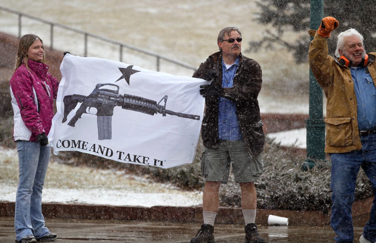 FILE - In this March 4, 2013 file photo, opponents of proposed gun control bills being considered by the Colorado Legislature hold a sign depicting an assault rifle, displaying it to those passing in cars, in front of the State Capitol, in Denver. When a gunman opened fire inside a packed movie theater in July of 2012, killing 12, it helped revive the national debate over gun control. But, as the trial of theater shooter James Holmes is scheduled to begin Monday, April 27, 2015, Colorados gun debate has quieted down. Its in a sort of gridlock, said nonpartisan Denver pollster Floyd Ciruli. (AP Photo/Brennan Linsley, file) (AP)