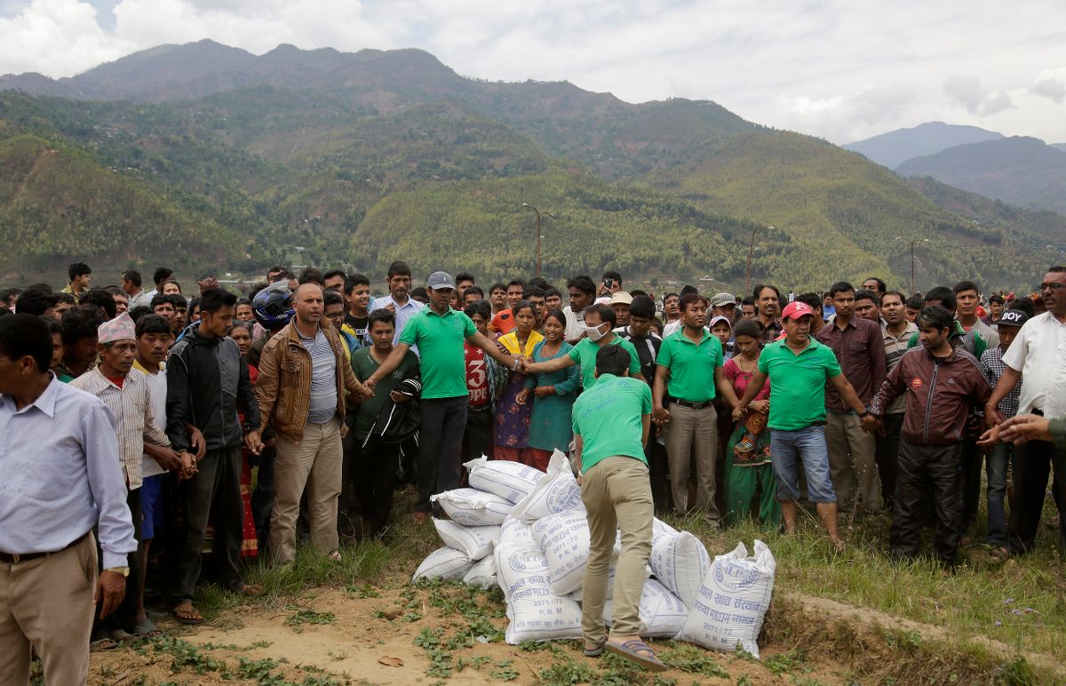 Nepalese volunteers unload relief material brought in an Indian air force helicopter for victims of Saturdays earthquake at Trishuli Bazar in Nepal, Monday, April 27, 2015. The death toll from Nepal's earthquake is expected to rise depended largely on the condition of vulnerable mountain villages that rescue workers were still struggling to reach two days after the disaster.  (AP Photo/Altaf Qadri) (AP)