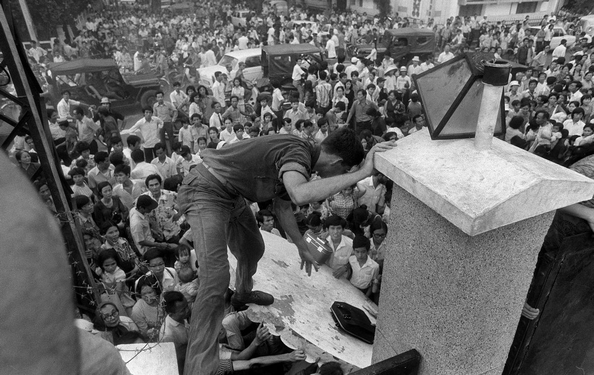 FILE - In this April 29, 1975, file photo, South Vietnamese civilians try to scale the 14-foot wall of the U.S. embassy in Saigon, trying to reach evacuation helicopters as the last Americans departed from Vietnam. More than two bitter decades of war in Vietnam ended with the last days of April 1975. (AP Photo/File) (AP)
